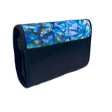 A rectangular cosmetic bag with which secures with a Velcro strip across the top. The front of the bag the inside of the iconic Kiwi Pāua shell with beautiful swirls of blue, green and purple. The back and sides are black, with a black Velcro strip and unfolds into 4 compartments. 